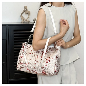Close-up of vintage silk shoulder bag with red plum blossom print and silver chain detail