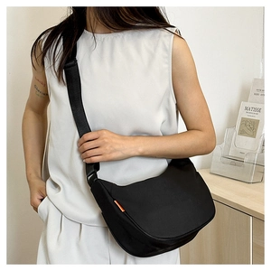 Detail view of the black nylon crossbody bag with adjustable strap and orange side label