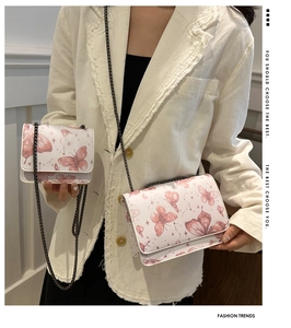 Détails de sacs bandoulière blancs à imprimé papillon avec chaîne sur mannequin de mode