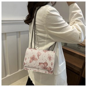 Chic white crossbody bag featuring pink butterfly patterns and metallic chain strap detail