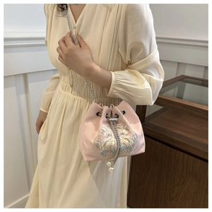 Detail der rosa Satin-Beuteltasche mit Blumenstickerei und Perlen-Kordelzug-Akzenten