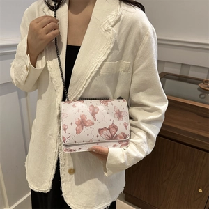 Chic pearl white crossbody chain bag featuring pink butterfly prints on model