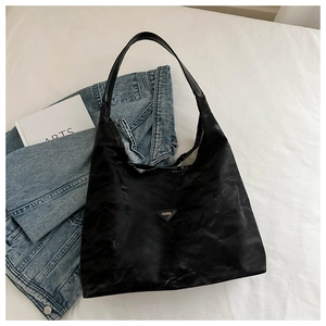 Vista dettagliata di una borsa hobo in nylon nero con logo moda su superficie bianca