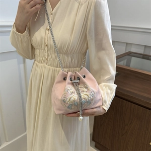 Rosa Satin-Beuteltasche mit Blumenstickerei und Silberkette am Modell präsentiert