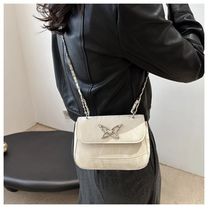 Detail of cream white leather crossbody bag with silver butterfly clasp and chain strap