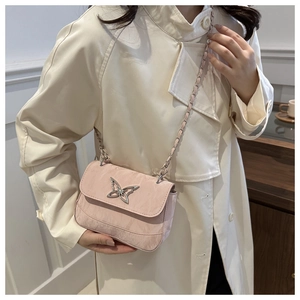 Detail of pink crossbody bag with silver butterfly buckle and fine pleated texture