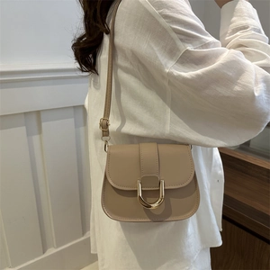 Chic beige leather crossbody saddle bag with gold horseshoe buckle for women