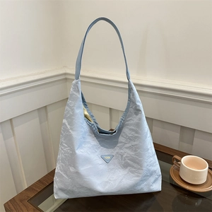 Borsa tote celeste stropicciata con stemma a triangolo su base di legno