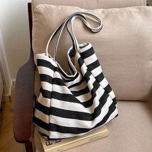 Minimalist black and white striped canvas tote bag on sofa with casual aesthetic vibe