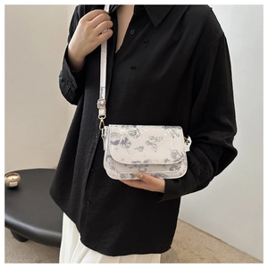 Close-up of a white crossbody square bag featuring butterfly prints and an adjustable strap