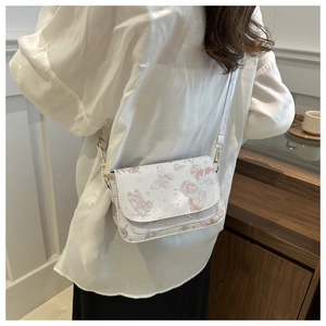 Back view of a model wearing a white crossbody bag with pink butterfly and star prints
