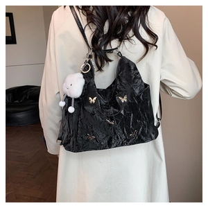Détail du sac noir avec ornements papillon et pendentif fantôme en peluche mignon