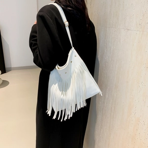 Witte franjes shopper met verstelbare schouderband, gepresenteerd door een model in studio