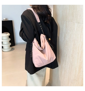 Close-up of pink nylon hobo bag with textured fabric and woven rope shoulder strap