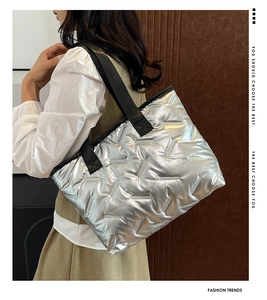 Detail of silver metallic quilted tote bag featuring geometric textured stitching