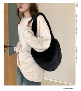 Détail d'un sac bandoulière en peluche noire en forme de croissant avec texture douce