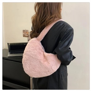 Sac hobo rose en peluche duveteuse porté par un mannequin dans un style tendance