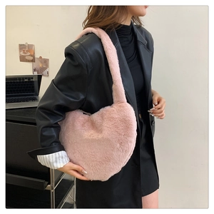 Détail d'un sac à bandoulière en peluche rose en forme de cœur avec texture en fausse fourrure