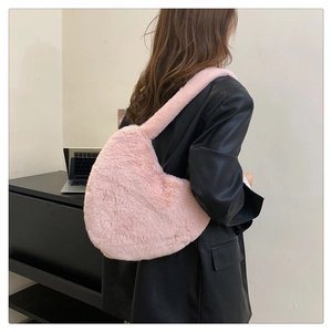 Vue arrière d'un sac à bandoulière en peluche rose porté avec une sangle confortable
