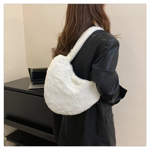 Vue arrière d'un mannequin portant un sac hobo en fausse fourrure blanche sur un manteau noir