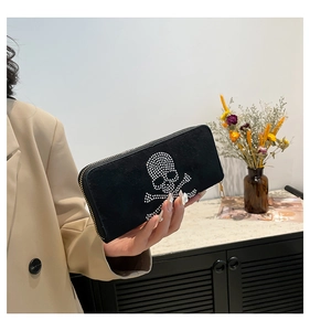 Detailed view of punk skull rhinestone pattern on black suede long wallet with metal zipper