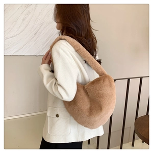 Sac hobo en peluche marron en fausse fourrure porté avec une veste blanche chic