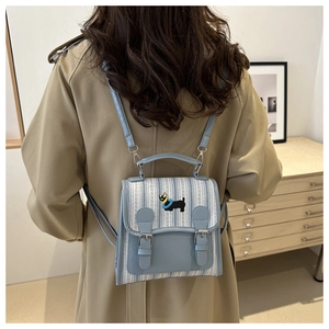 Rear view of a model wearing a mini light blue striped PU leather backpack