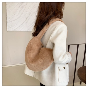 Modèle portant un sac hobo croissant en peluche marron doux pour l'automne et l'hiver