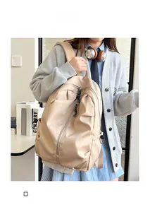 Detail of beige nylon backpack with natural wrinkle texture and side pocket for students