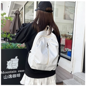 Side view of white water-resistant nylon backpack for women in outdoor sunny cafe