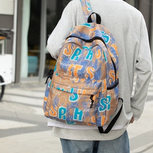 Close-up of khaki backpack with colorful graffiti lettering worn in street scene