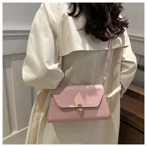 Détail du sac bandoulière rose en similicuir avec boucle dorée à double anneau