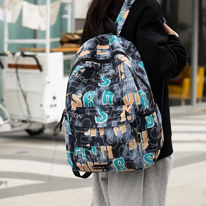 Detailed outdoor view of graffiti print backpack featuring adjustable straps and zipper