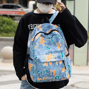 Detail of blue street-style backpack with colorful graffiti prints and front pocket