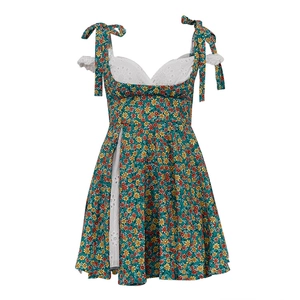 Detail van donkergroene zomerjurk met bloemenprint, wit kantwerk en een zijsplit