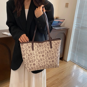 Large beige tote bag with letter print and brown handles for daily commute use