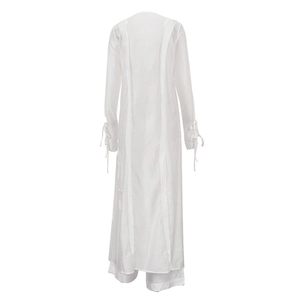 Vue détaillée du dos d'un caftan de plage blanc avec poignets à nœuds papillon