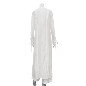 Détail des poignets à cordon réglable sur un cardigan blanc transparent et pantalon large