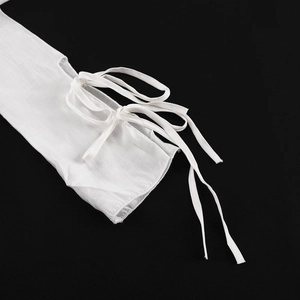 Détail de la manchette de manche blanche avec nœud et texture de dentelle ajourée