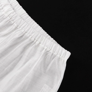 Détail du pantalon en coton et lin blanc avec taille élastique et texture plissée