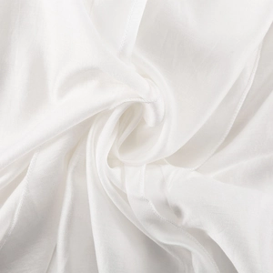Gros plan sur le tissu en mousseline blanche montrant la texture fine et les coutures nettes