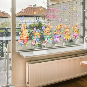 Detailed view of colorful Easter bunny window stickers on glass with floral pots