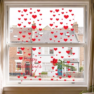 Detail of red heart window clings and Happy Valentine's Day text on glass