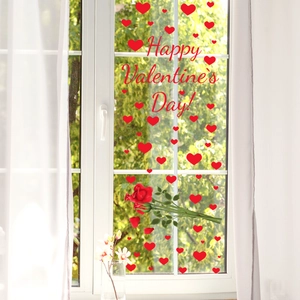 Red Valentine's Day heart and rose window stickers on glass with a bright garden view