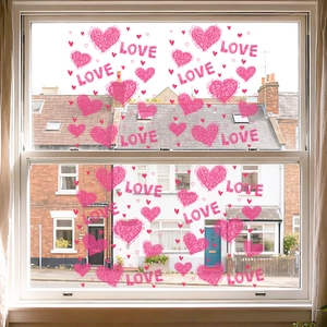 Pink hand-drawn heart and LOVE stickers applied to a bright glass window for home decor