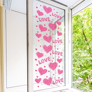 Pink heart and LOVE letter static window decals on glass with a green outdoor background