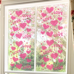 Close-up of pink heart and LOVE lettering static window stickers on a glass surface
