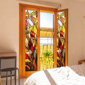 Stained glass window film with colorful leaf patterns casting light shadows on a bed