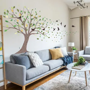 Detailed wall sticker showing a brown tree with falling leaves and birds on a living room wall