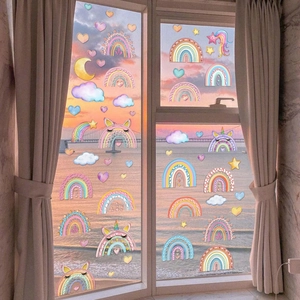 Rainbow and unicorn static window stickers on a glass window with soft sunset beach view